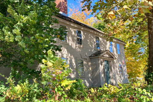 Front of Nathaniel Ingersoll's Ordinary house in Danvers, MA. Trees surround the deteriorating property.