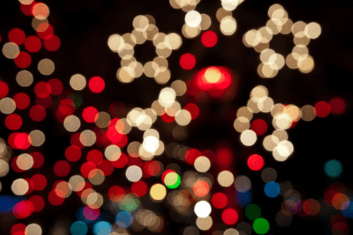 Colorful bokeh lights in star shapes, creating a festive and blurred holiday atmosphere.