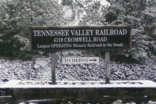 Sign for Tennessee Valley Railroad, located at 4119 Cromwell Road, with snow-covered surroundings. Arrow points to depot.