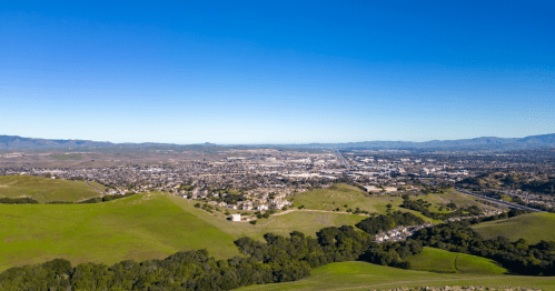 An aerial view of Dublin, California, and its surrounding green hills.