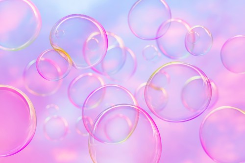 Colorful soap bubbles floating against a soft pastel background of pink and blue hues.
