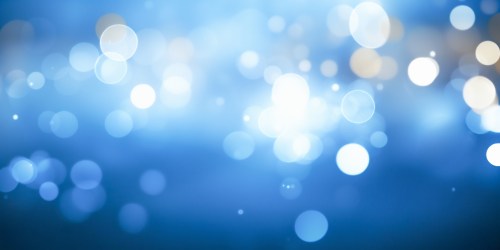 Abstract blue background with soft, blurred bokeh lights in various sizes, creating a dreamy, ethereal effect.