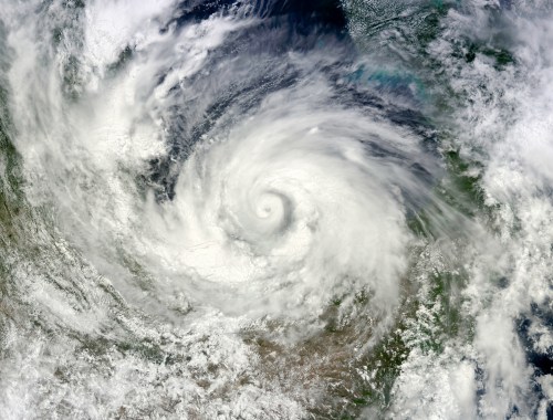 Satellite image of a swirling hurricane over land, showcasing dense clouds and a clear eye at the center.