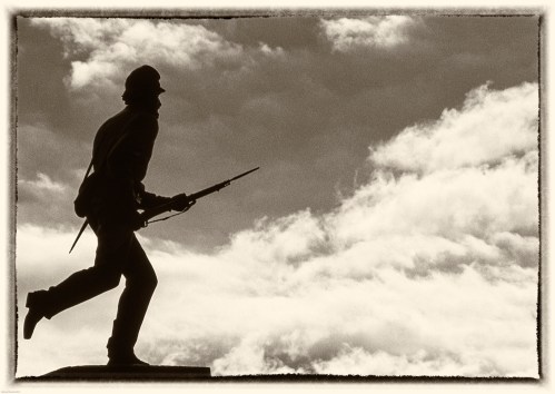 Silhouette of a soldier holding a rifle against a cloudy sky, evoking themes of bravery and sacrifice.