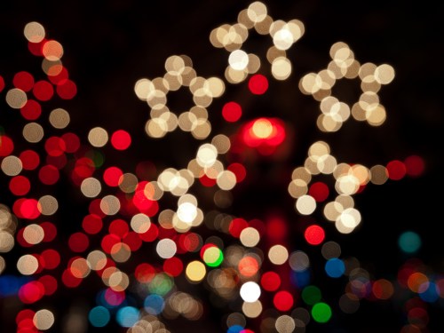 A blurred background of colorful holiday lights in red, white, and green, creating a festive atmosphere.