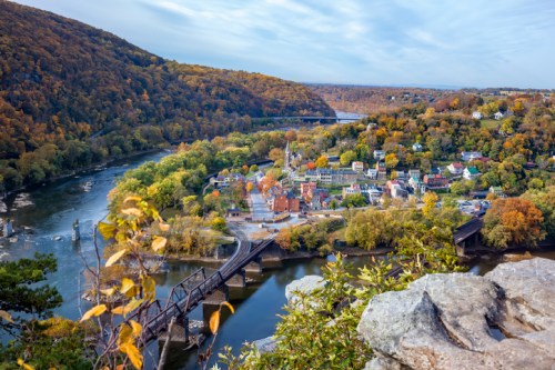 Aerial view of a small town flanked by a river and mountains at dawn
