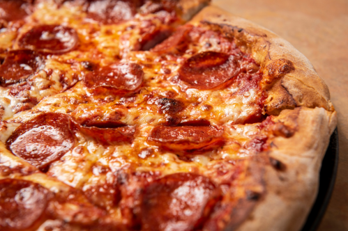 Close-up of a pepperoni pizza with melted cheese and a golden-brown crust.