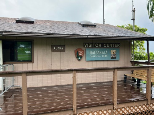 Exterior of the Haleakalā National Park Visitor Center, featuring a sign that says "Aloha" and park information.