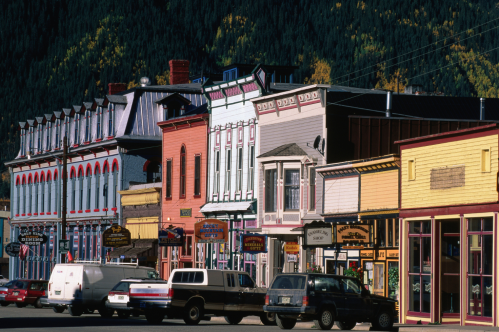Colorful historic buildings line a street, showcasing a mix of architectural styles in a charming small town.
