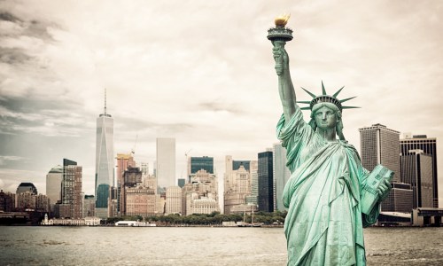 Statue of Liberty with the New York City skyline in the background on a clear day.