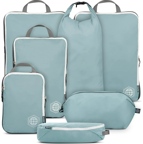 A set of light blue travel bags in various sizes, including packing cubes and a duffel, arranged together.