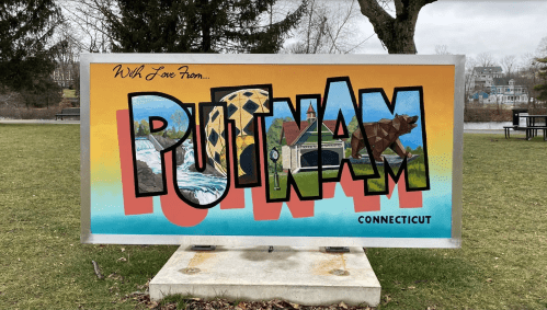 Colorful mural sign reading "PUTNAM" with scenic elements, located in Putnam, Connecticut.