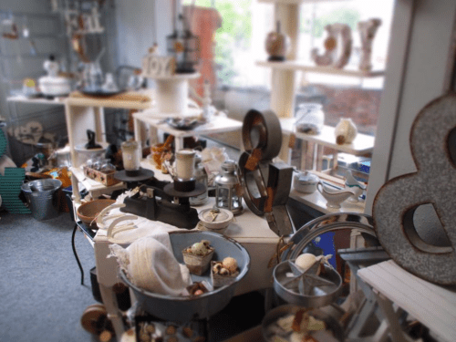 A cozy shop interior filled with various decorative items, including candles, pottery, and unique displays.