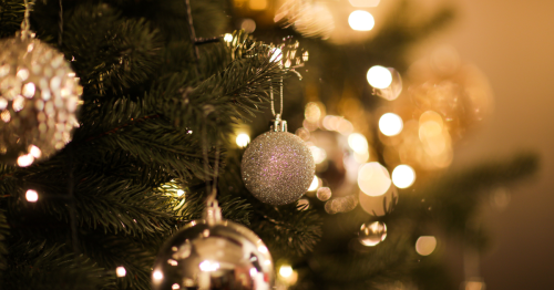 Close up view of a Christmas tree with silver and gold ornaments.