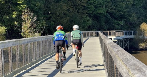 Two cyclists cross a boardwalk trail in Morrisville, North Carolina.