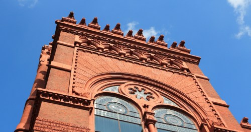 Exterior of architectural detail of Fisher Fine Arts Library in PA against a blue sky.
