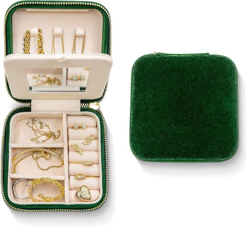 A green jewelry case opened to reveal various gold pieces, including necklaces, rings, and earrings, neatly organized inside.