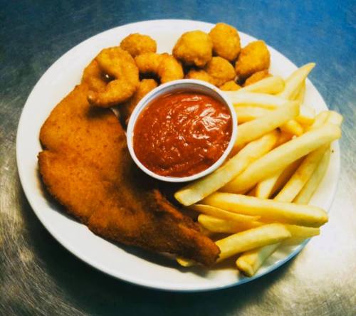 A plate of fried fish, shrimp, hushpuppies, and French fries with a side of dipping sauce.