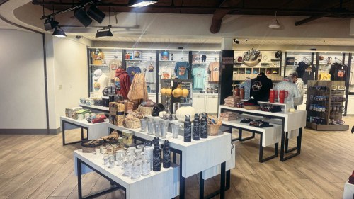 A retail store interior featuring various merchandise displays, including clothing, souvenirs, and home goods.
