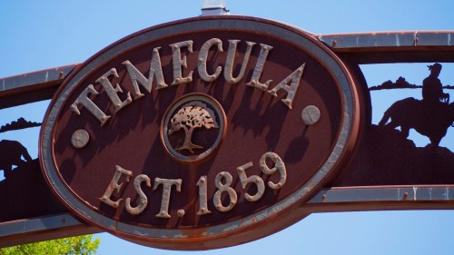 Sign for Temecula, established in 1859, featuring a tree and silhouette of a cowboy.