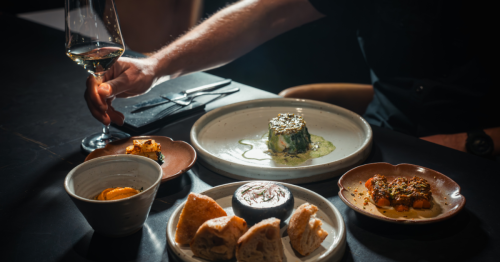 view someone with a wine glass in one sitting at a table with dishes of food set at nonesuch in oklahoma