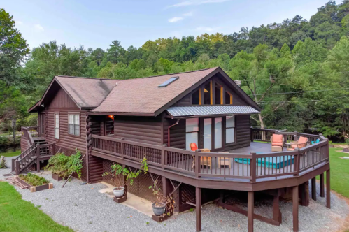 Exterior of the brown log Airbnb in the woods.
