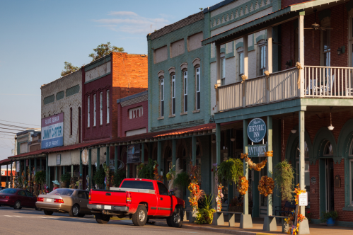 Main Street on Plains, Georgia, with shops and restaurants and cars parked out front.