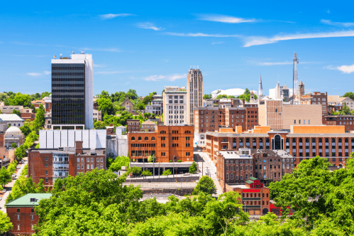 View of Lynchburg, Virginia skyline with trees and blue sky.