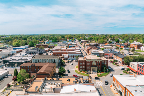 Aerial view of Elizabethtown, Kentucky with buildings on streets and a blue sky.