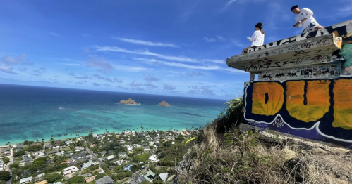 A WWII-era pillbox looks over an electric-blue Pacific Ocean, with hikers sitting on the roof.