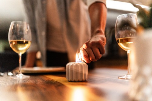 Close-up of a man lighting candle for romantic dinner