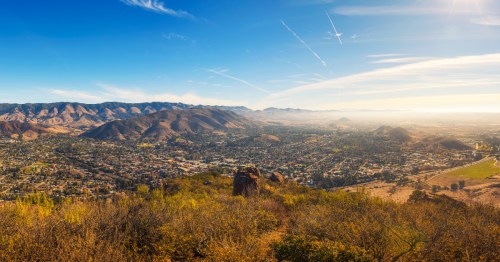 Standing on a hillside overlooking San Luis Obispo, California, on a blue sky day.