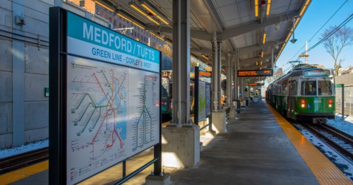 the medford/tuftst green line stop for the T with a subway train pulling up to the station in medford massachusetts