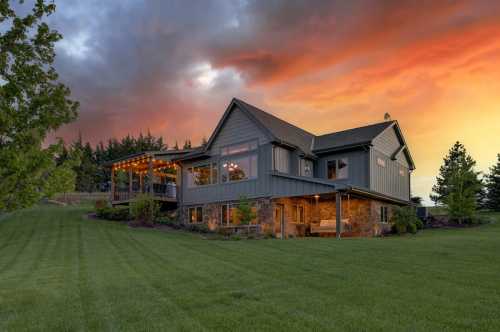 A large luxury cabin in Nebraska sits under a gorgeous orange and blue dusk-hued sky.