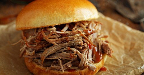 a pulled pork sandwich on a piece of brown paper