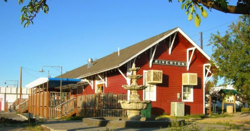 An old railroad depot for the town of Riverton, Wyoming, housed inside a historic, red farmhouse-style building.