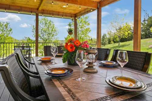 A gorgeously arranged table sits on an open patio overlooking the rolling greenery of a gorgeous Nebraska landscape.