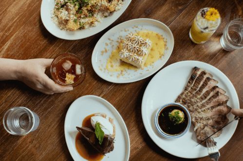 Aerial view of table dishes, drinks, and desserts at Helen in Birmingham.