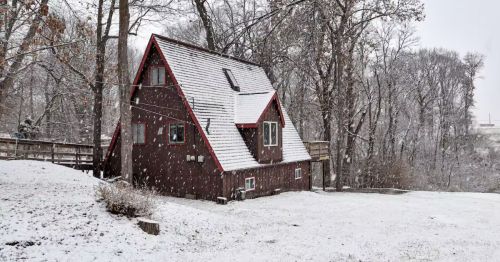 An A-frame cabin covered in show.