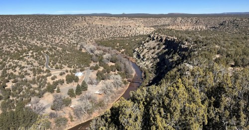 Looking down at the Pecos River and desert landscape from a New Mexico hiking trail on a winter day.