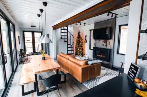 A cozy sitting space in an Ohio Airbnb complete with a table, a couch, and a Christmas tree.