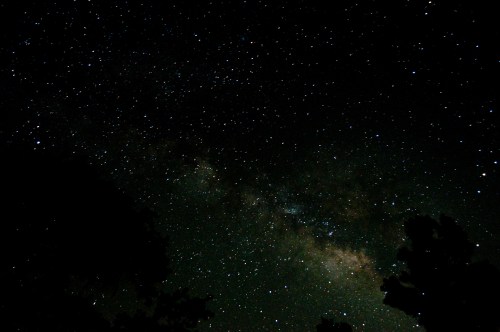Dark night sky filled with countless stars and the faint glow of the Milky Way.