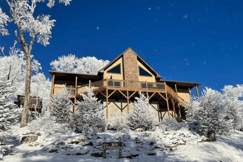 Exterior of a snowy cabin in North Carolina with bright blue skies.