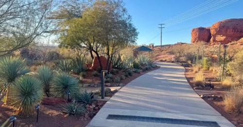A wide sidewalk winds through a desert garden in St. George, Utah.