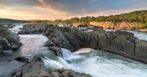 Water flowing down the Great Falls Park in Virginia during sunset.