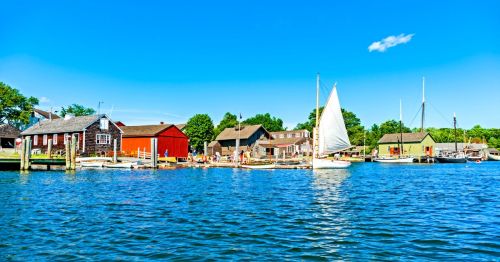 a sunny day on the water at Mystic Seaport in Mystic, Connecticut near sailboats and houses