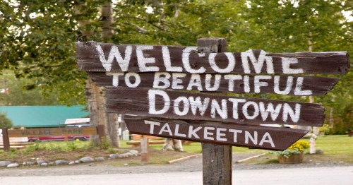 A wooden sign in Talkeetna, AK that reads "Welcome to Beautiful Downtown Talkeetna"
