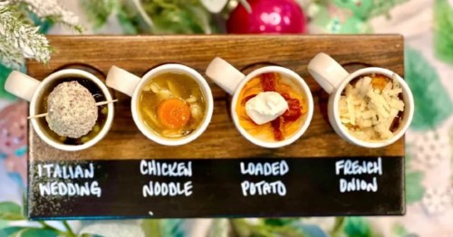 A festive soup flight at Little Birdie Wine Nest in Parma, Ohio. Four mini soup cups are arranged on a wooden board, each featuring a different variety.
