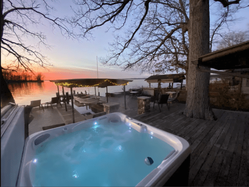 A hot tub sits before a lake with a setting sun in Ohio.