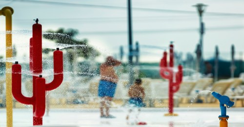 son and dad playing in cacti water fountains